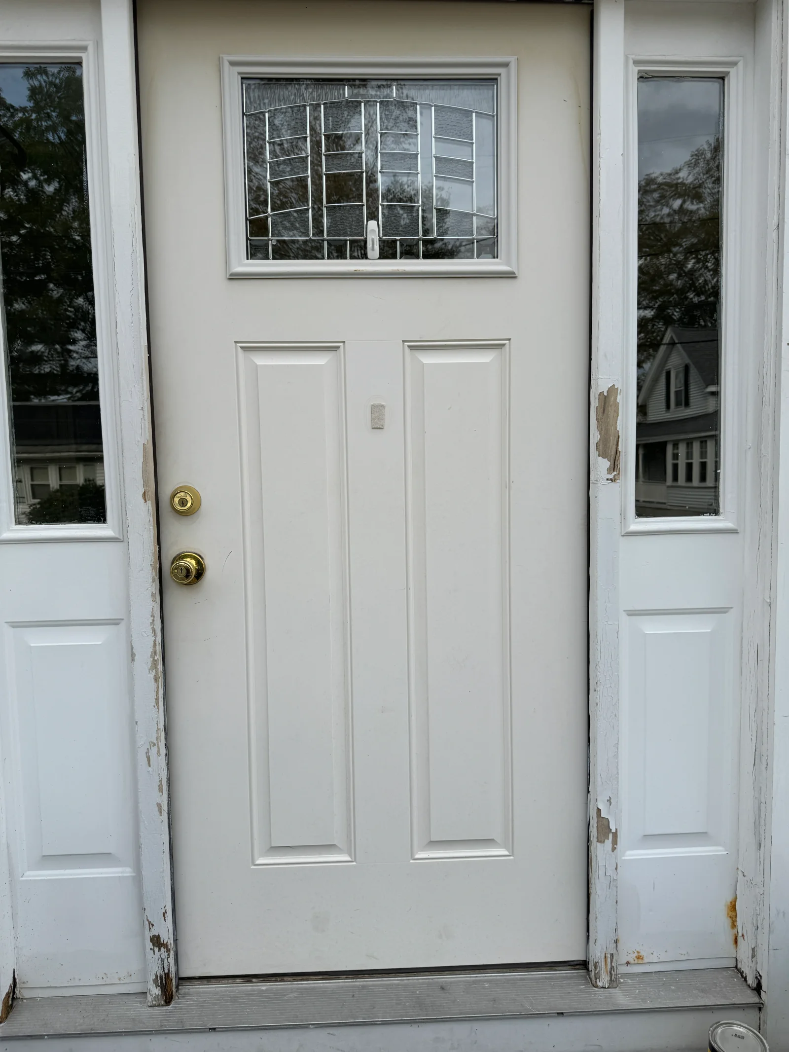 White entry door with sidelights cleaned, showing restored finish on door frame and trim