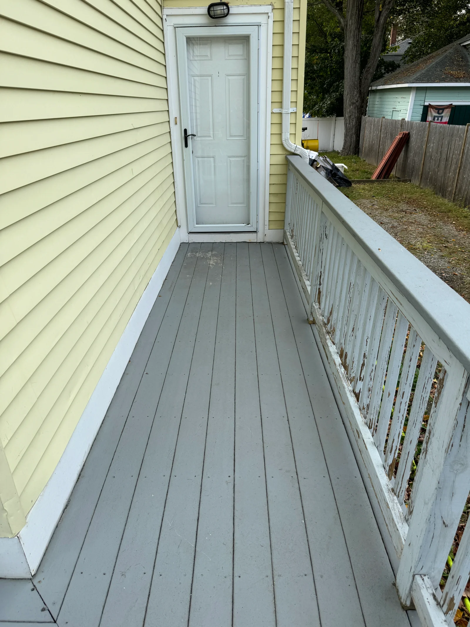 Pressure-washed composite deck with clean gray boards and white railing trim