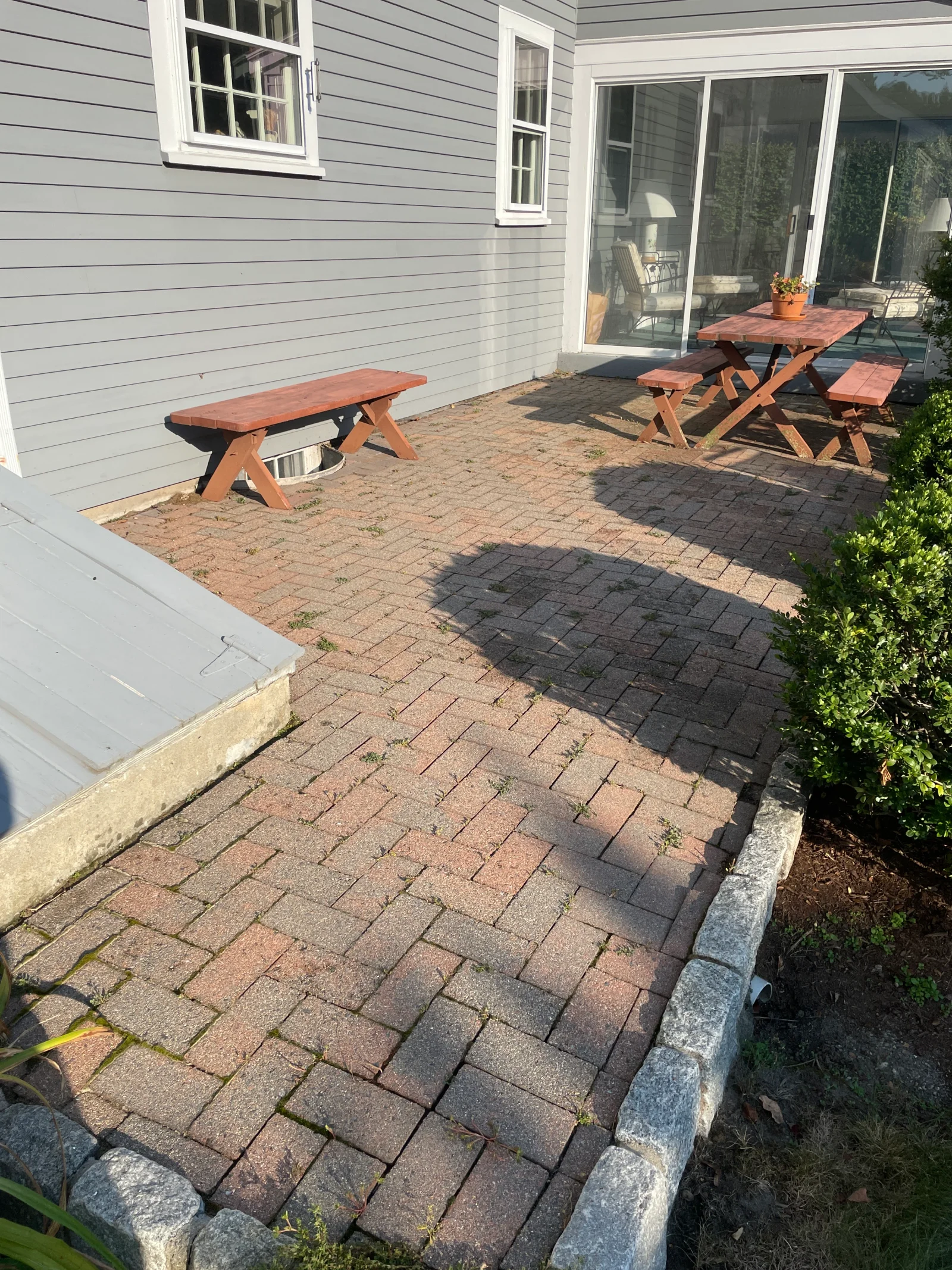 Brick paver patio and driveway after pressure washing, showing clean surface restoration